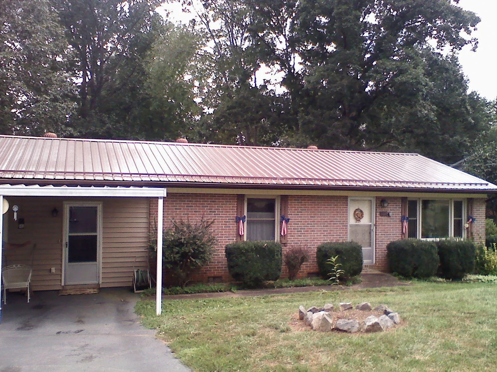 Bronze metal roof and carport on a brick ranch home — Roof Repair work by our crew in Cashion